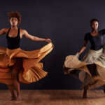 Our Projects Feminine freedom. Two contemporary dancers with flowing skirts in front of a dark background