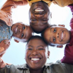 Our Projects Shot of a young family of four standing together in a huddle.